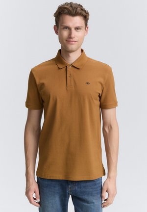Polo shirt marrón en una suave mezcla de algodón, con cuello de solapa, cierre de tres botones y un pequeño logo en el lado izquierdo del pecho.