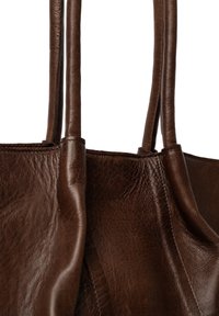 Brązowa skórzana torba na ramię o gładkiej teksturze, z podwójnymi mocnymi uchwytami i szwem wzdłuż krawędzi, prezentująca minimalistyczny design.