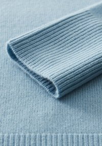 Maglione azzurro chiaro in maglia con texture a coste. Presenta un polsino ripiegato e un corpo liscio, che mette in risalto l'ottima lavorazione e il materiale morbido.