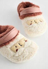 Pantofole bianche morbide con una texture cremosa, dotate di un bordo in pelliccia rosa e di un volto di cartone animato giocoso con dettagli ricamati su ciascuna scarpa.