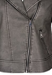 Giacca in finta pelle grigia con chiusura a zip diagonale, colletto asimmetrico e due tasche laterali con zip. Finitura testurizzata visibile.