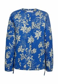 Blå quiltet jakke med hvidt blomstermønster, rund hals, lange ærmer og lukning fortil. Har snore i siderne ved kanten.