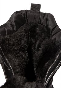 Bota de invierno negra con un interior de peluche de piel sintética, tela exterior suave y un cordón en la parte superior. Detalle de cremallera en el costado para facilitar su uso.