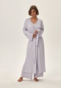 Jasnolawendowy, długi szlafrok z szerokimi rękawami, z zapięciem na sznurku oraz warstwowym fasonem na pasujące spodnie; wykonany z miękkiego, delikatnie opadającego materiału.