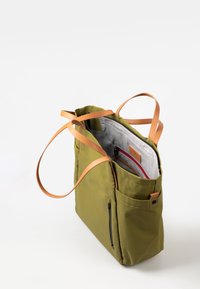 Borsa tote verde con manici in pelle marrone, interni testurizzati, molteplici scomparti e una tasca anteriore con zip. Presenta un'etichetta logo discreta.