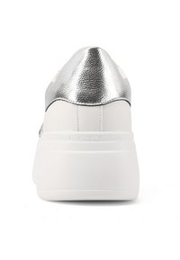 Sneaker bianco con un tallone metallico argento. Presenta una texture liscia, una forma arrotondata e una suola spessa e piatta. Design minimalista senza motivi.