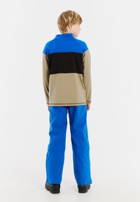 Fleece top, modré, čierne a béžové farebné bloky. Spárované s modrými nohavicami, obe vyrobené z syntetických materiálov. Textúrovaný povrch s golierom.