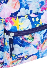 Zaino colorato con un tessuto blu decorato da motivi celestiali, inclusi stelle e pianeti, e una tasca frontale con cerniera con dettagli viola.