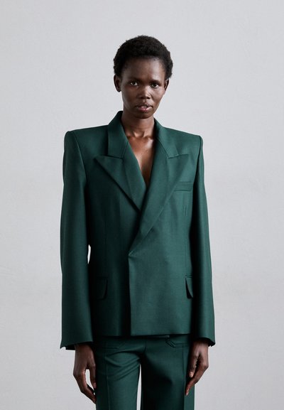 Dunkelgrüner, taillierter, zweireihiger Blazer mit großen, abgesetzten Revers, zwei vorderen Taschen und strukturierten Schultern. Glatte Stoffoberfläche.