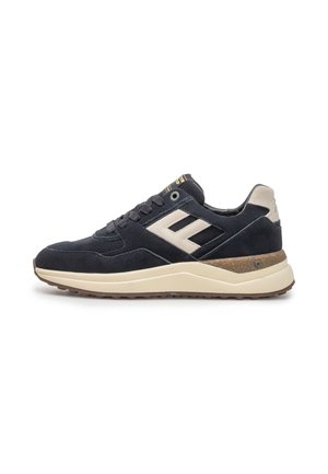 Sneaker in suede nero e beige con suola crema e design con lacci, dettaglio logo laterale e accento midsole marrone testurizzato.