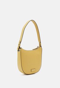 Borsa a spalla gialla in pelle con un design curvo, parte superiore piatta, spallaccio regolabile e profili neri a contrasto. Presenta una tasca frontale e un dettaglio del logo.