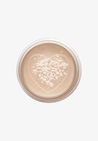 Translucent loose powder in a round, clear container with a heart-shaped design. The powder appears light with a soft texture and matte finish.