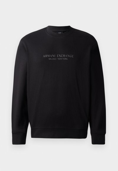 Sweat-shirt noir à col rond avec "ARMANI EXCHANGE MILANO / NEW YORK" en texte en relief sur le devant. Le tissu est lisse avec des poignets côtelés.