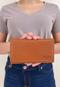 Braune Lederbörse mit glatter Textur, zweifachem Design und kontrastierenden Nähten, mit dem eingeprägten Logo "Gusti Leder studio".