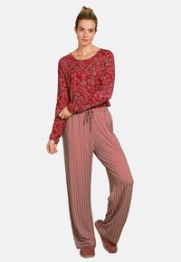 Red floral long-sleeve top paired with striped wide-leg pants in shades of red, cream, and brown. Comfortable fabric with a relaxed fit.