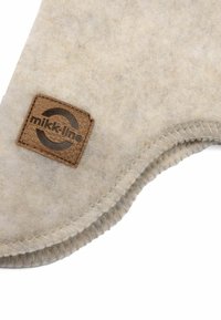 Beiger Filzmatte mit abgerundetem Rand, ausgestattet mit einem braunen Lederpatch, das mit dem "mikk-line"-Logo geprägt ist und dekorativen Nähten entlang des Randes.