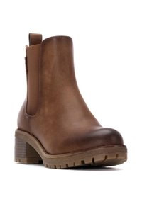 Botín de cuero marrón hasta el tobillo con punta redondeada y tacón grueso. Cuenta con paneles laterales elásticos y una suela de goma texturizada.