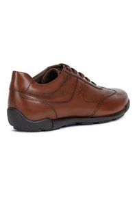 Chaussures en cuir marron à forme arrondie, présentant des détails de couture minimes et une semelle en caoutchouc noire pour la stabilité et le confort.