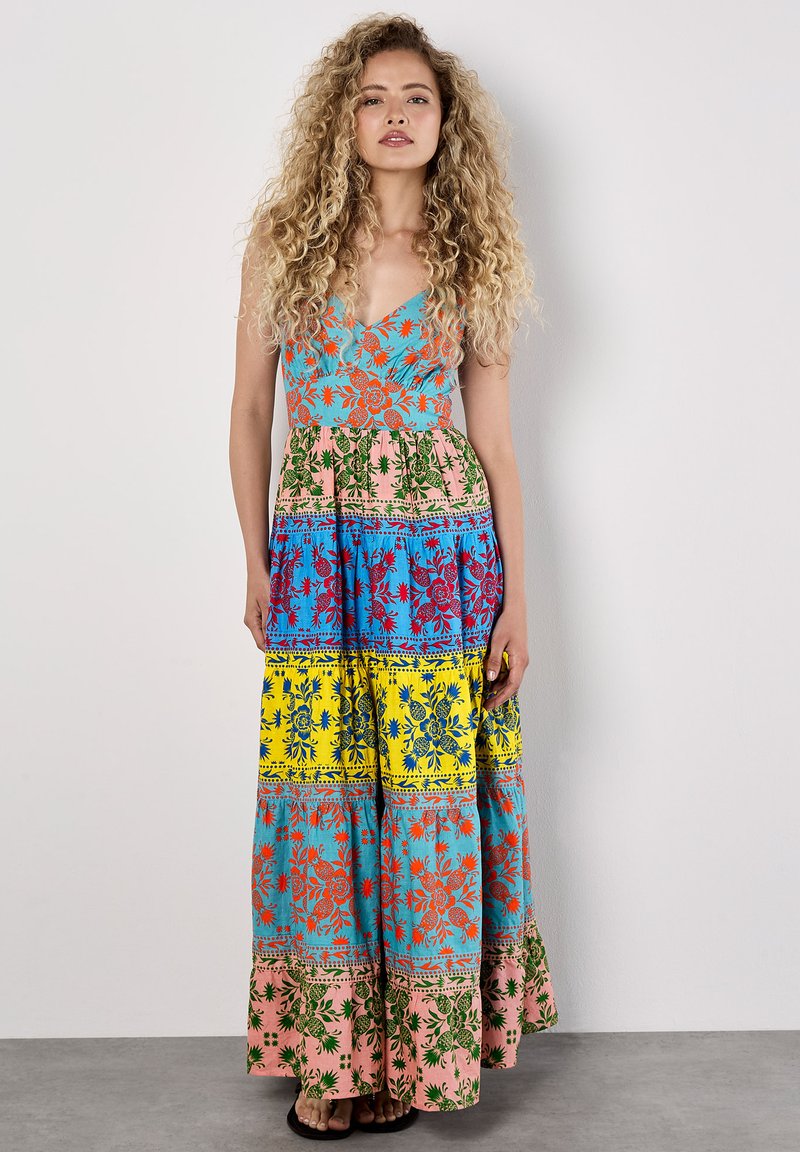 Robe maxi multicolore avec un col en V, présentant des motifs floraux en bleu, vert, rose, jaune et rouge. Tissu léger avec un design fluide.