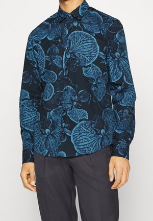 Camicia a maniche lunghe da uomo realizzata in tessuto scuro con un motivo floreale blu. Ha un design con bottoni e un colletto a punta.