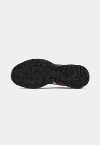 Sports shoe sole featuring a rugged black rubber texture with multi-directional tread patterns for enhanced grip and traction.