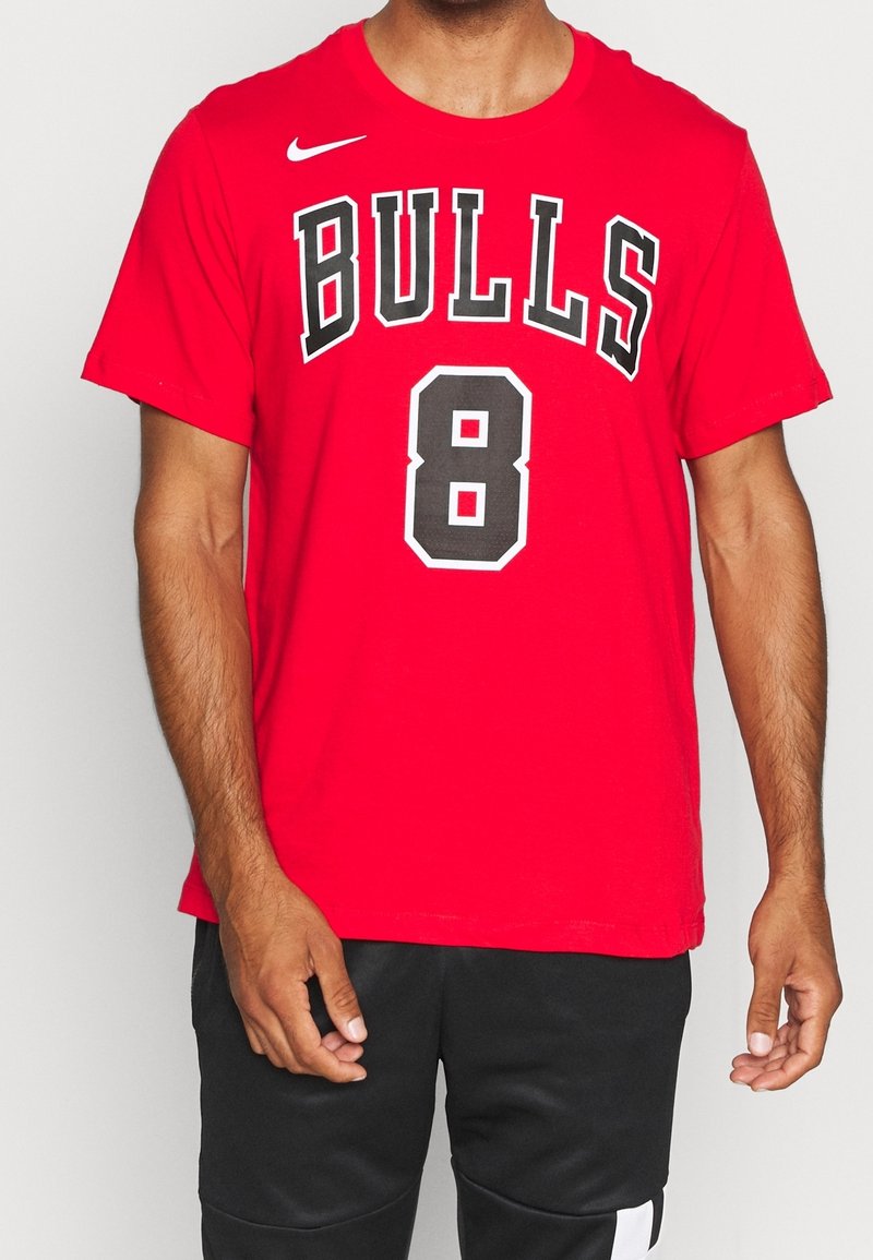 Camiseta de Nike de manga corta roja con "BULLS" en negro sobre el número "8" en negro contorneado en blanco. Tejido suave, corte relajado.