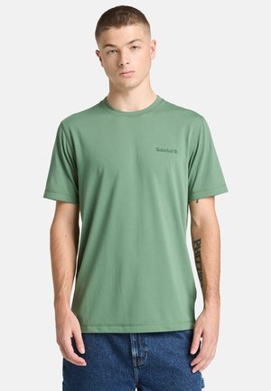 Maglietta verde a maniche corte in tessuto liscio, con scollo rotondo e discreto logo Timberland sul petto.