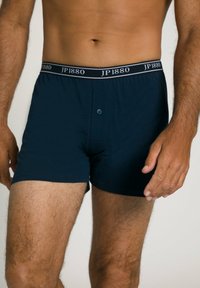 Marineblaue Boxershorts mit Knopfverschluss aus weichem Stoff. Mit einem kontrastierenden grauen Bund, der das Logo "JP1880" trägt.