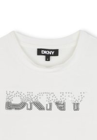 Witte DKNY T-shirt met een ronde halslijn, voorzien van een zwart label en een zilveren pailletten DKNY-logo op de borst.