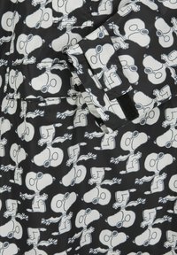 Schwarzer Stoff mit einem wiederholten Design eines weißen Cartoon-Charakters. Der Charakter trägt Sonnenbrillen, hat einen Schal und erscheint in verschiedenen Posen mit einem verspielten Ausdruck.