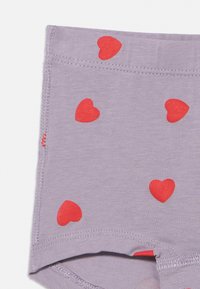 Lys lilla bomullstruse med spredte røde hjerte mønstre, med myk tekstur og elastisk linning for komfort.