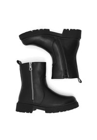 Botines negros de cuero con cremallera lateral, parte superior texturizada, suelas gruesas de goma y lengüeta en el talón para facilitar su uso.