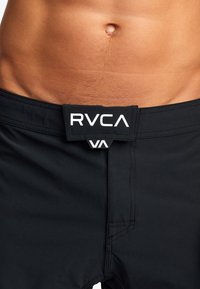 Sorte RVCA-shorts med en glat tekstur, elastisk talje med logo og minimale syninger. Designet er moderne og elegant.