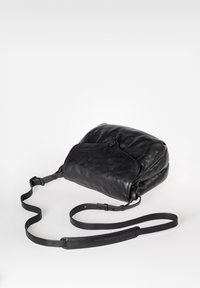 Borsa in pelle nera con una superficie morbida e texture. Presenta una chiusura con zip sulla parte superiore e una tracolla regolabile. Forma compatta e arrotondata con una tasca frontale.