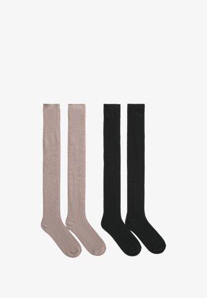 Calze fino al ginocchio in beige chiaro e nero. Texture a coste con punte rotonde, finitura liscia e bordi risvoltati. Quattro calze in totale mostrate.