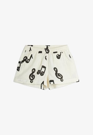 White cotton shorts with a black music note pattern, featuring an elastic waistband and side pockets. Casual design, lightweight texture.