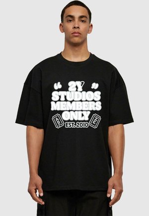 Black oversized t-shirt made of cotton with a round neck. Features white graphic text: “2Y STUDIOS MEMBERS ONLY” and “EST. 2010.”