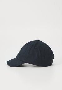 Căciulă de baseball bleumarin, cu o margine curbată, coroana structurată, orificii de ventilație și un accent mic cu logo pe lateral.