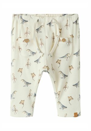 Kremowe dziecięce spodnie z nadrukami morskich zwierząt, w tym rekinów, ośmiornic i płaszczek, z dwoma przednimi kieszeniami zapinanymi na drewniane guziki oraz ściągaczem w pasie.