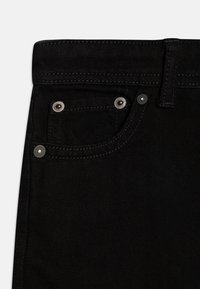 Svarte denimjeans med en frontlomme med sølvfarget beslag, kontrasterende sømmer og en glatt tekstur. Stoffet virker slitesterkt.