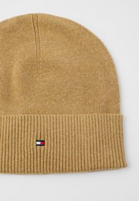 Berretto lavorato a maglia color cammello con risvolto a costine e piccolo logo rettangolare rosso, bianco e blu ricamato sul risvolto anteriore.