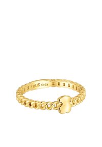 Złoty pierścionek o plecionym wzorze, z małym akcentem w kształcie koniczyny. Wnętrze obrączki grawerowane napisem "TOUS S925".