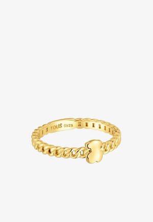 Goldfarbener Ring mit geflochtenem Design, verziert mit einem kleinen Kleeblatt-Akzent. Innen im Ring ist "TOUS S925" eingraviert.