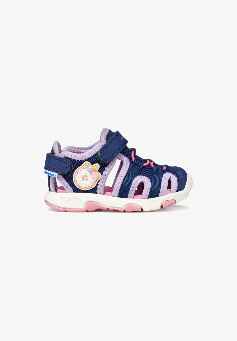 Sandale pour enfants bleu marine et lavande avec accents roses, côtés ouverts, brides ajustables et un patch licorne en forme de beignet sur le talon.