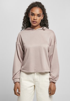Pink cropped hoodie in soft fabric with a relaxed fit. Features a drawstring hood and wide sleeves with elastic cuffs. Paired with white pants.