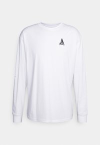 Weißes Langarm-T-Shirt aus Baumwolle. Verfügt über ein kleines schwarzes Logo auf der Brust und gerippte Bündchen. Einfaches, einfarbiges Design.