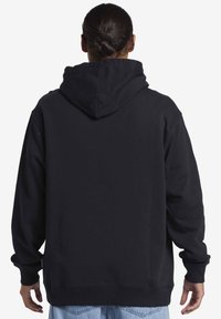 Sudadera con capucha negra de corte relajado, con puños y base acanalados. Textura suave, con un diseño sencillo y sin gráficos.