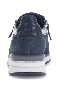 Marineblauwe sneaker van een combinatie van glad en gestructureerd suede. Beschikt over een witte zool en een rits aan de zijkant voor gemakkelijk aantrekken.