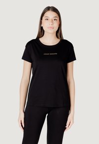 T-shirt nera a maniche corte in cotone, con scollatura rotonda e logo dorato "Armani Exchange" sul petto.