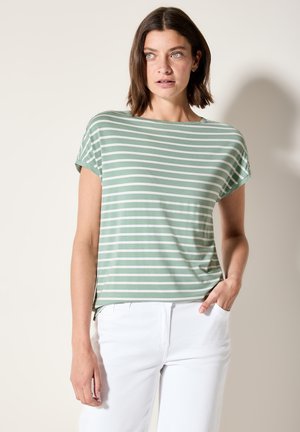 Haut à manches courtes rayé vert et blanc avec une coupe décontractée et un col rond. Associe avec un pantalon blanc, affichant un look décontracté.